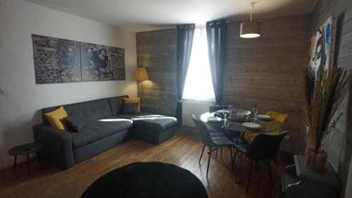 a living room with a couch and a table at Coeur de ville, calme, spacieux,Parking et wifi ! in Chartres