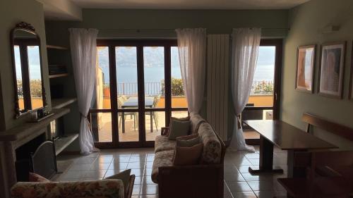 - un salon avec un canapé et une vue sur l'océan dans l'établissement Few steps to the heart of Menaggio, swimming pool, breathtaking view, à Menaggio