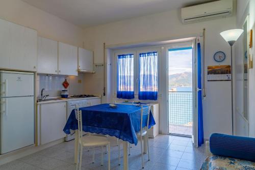een keuken met een tafel met een blauwe tafeldoek bij Appartamento Miramare in Portoferraio