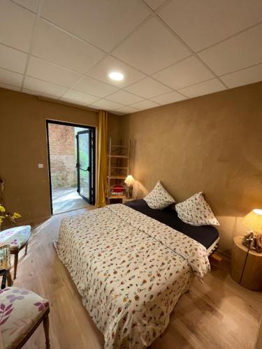 um quarto com uma cama grande e uma janela em Double room on farm (La ferme du Tao) em Beaugies-sous-Bois