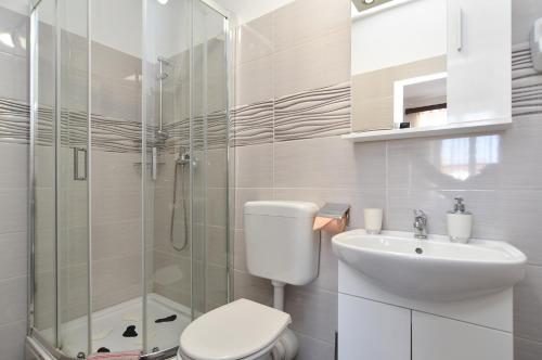 a bathroom with a shower and a toilet and a sink at Rooms Bale 2150 in Bale