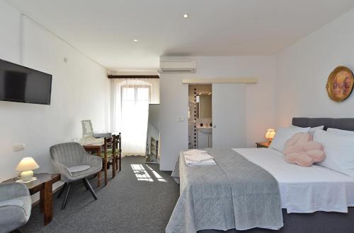 a bedroom with a bed and a table and a chair at Rooms Bale 2150 in Bale