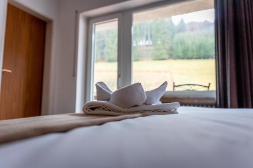 a white hat on top of a bed with a window at Hotel Tiefenhagen Sauerland in Lennestadt