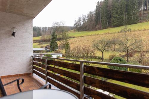a balcony with a view of a field and trees at Hotel Tiefenhagen Sauerland in Lennestadt