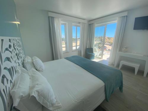 a bedroom with a large white bed and a window at Mareta Beach - Boutique Bed & Breakfast in Sagres