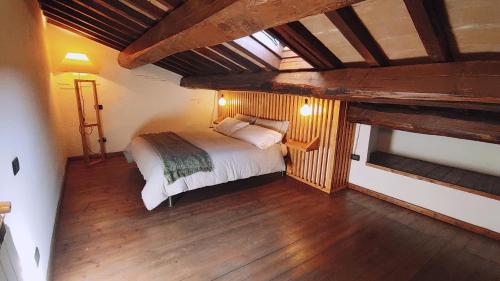 ein Schlafzimmer mit einem Bett in einem Zimmer mit Holzböden in der Unterkunft Piazza Duomo casa vacanze in Sutri
