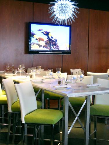 a dining room with a table with chairs and a tv at Novotel Toronto North York in Toronto