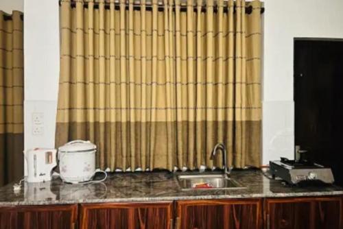 a kitchen with a sink and a shower curtain at Breezy Brand-New Green Tops Villa in Battaramulla