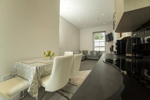 a kitchen with a table and chairs and a living room at Dympna's City Centre apartment, Armagh in Armagh