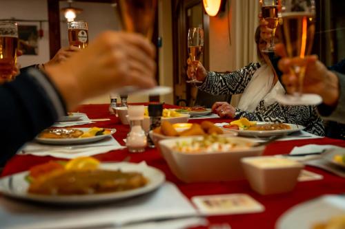 a group of people sitting at a table with plates of food at Hotel Tiefenhagen Sauerland in Lennestadt
