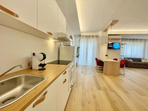 a kitchen with a sink and a living room at Barirooms - Picca 24 in Bari