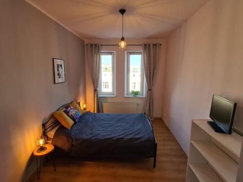 - une chambre avec un lit, une télévision et une fenêtre dans l'établissement Jazz Apartment in the centre of heart in Szczecin, à Szczecin