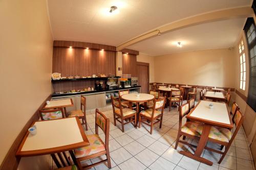 a restaurant with tables and chairs and a counter at Hotel Itamarati in Sao Jose do Rio Preto