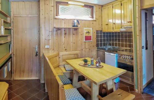 uma pequena cozinha com mesa e banco em Bormio Little house em Bormio