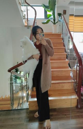 a woman sitting on stairs holding a white cat at Hoshi DaLat House in Da Lat