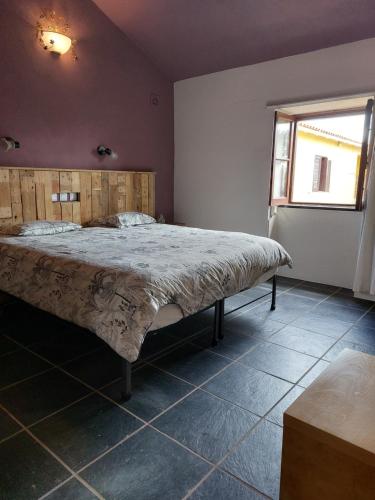 a bedroom with a large bed in a room with a window at Quinta Cunte - Casa Sobreiro in São Luis