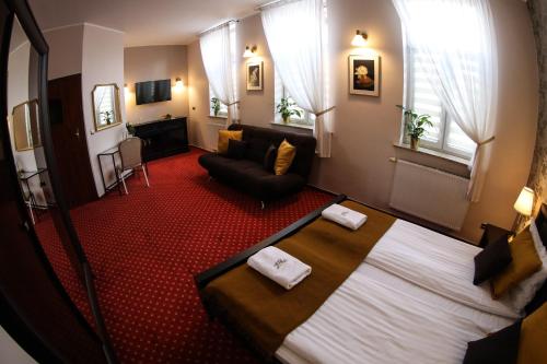 a hotel room with a bed and a living room at Valdi Classic in Zabrze
