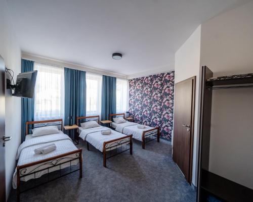 a hotel room with two beds and a tv at Kelman Inn Global Nowa Sól in Nowa Sól