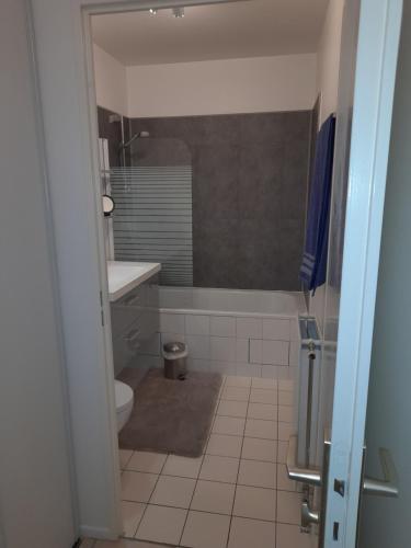 ein Badezimmer mit einer Badewanne, einem WC und einem Waschbecken in der Unterkunft Studio Meublé in Bussy-Saint-Georges