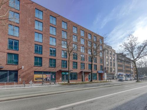 a red brick building on a city street at Limehome Münster Von-Steuben-Str - Digital Access in Münster