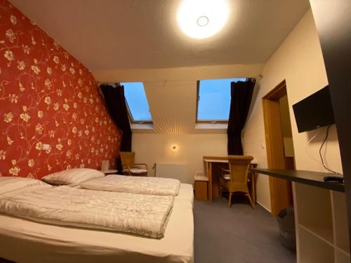 een slaapkamer met een bed en een bureau met een televisie bij Apartments Starlight Hotel Wiesmann in Bochum