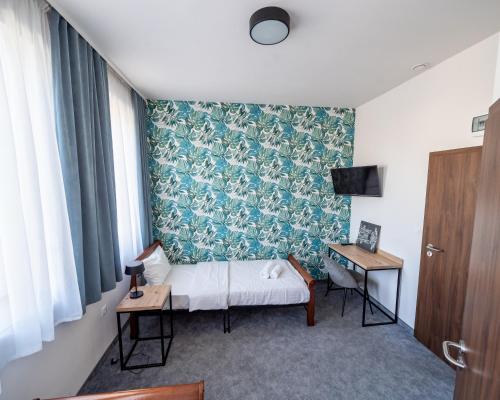 a bedroom with a bed and a wall with blue and white wallpaper at Kelman Inn Global Nowa Sól in Nowa Sól