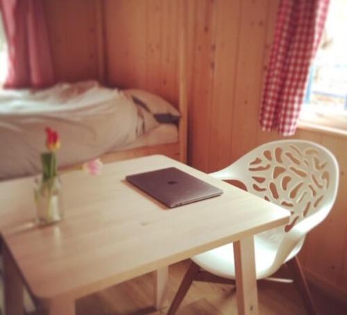 einen Tisch und einen Stuhl mit einem Laptop darauf in der Unterkunft Buiten aan de Baak in Steenbergen