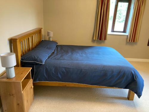 um quarto com uma cama com um edredão azul em Beautiful & Quiet Countryside Setting in Kinsale em Cork