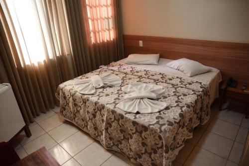 a bedroom with a bed with two towels on it at Hotel Itamarati in Sao Jose do Rio Preto