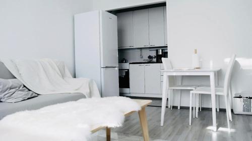 Sala de estar blanca con sofá y mesa en Ilona Apartments - "The City Condo" en Kotka