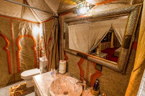 - Baño con lavabo y aseo en una tienda en Merzouga Desert camp, en Merzouga