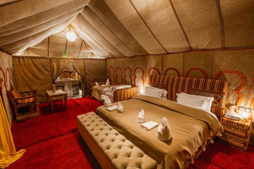 A bed or beds in a room at Merzouga Desert camp