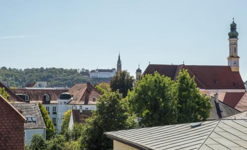 a view of a city with a clock tower and buildings at Simones Hotel Fürstenhof in Landshut