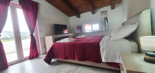 - une chambre avec un grand lit et une couverture rouge dans l'établissement Alepou Guest House, à Gasperina