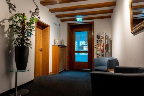 a living room with a chair and a potted plant at Hotel Tiefenhagen Sauerland in Lennestadt