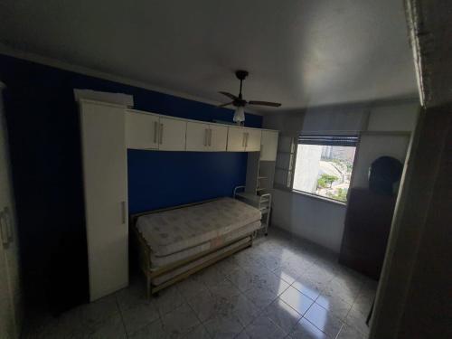 a bedroom with a bed and a blue wall at Apto frente à praia, aconchegante, vista lateral pro mar! in São Vicente