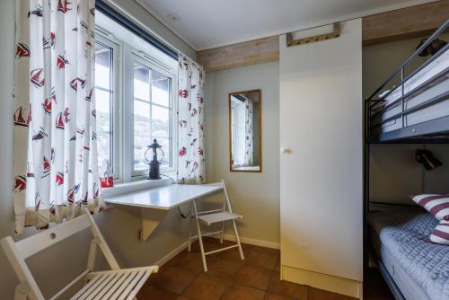 a room with a desk and a bed and a window at Resö Hamnmagasin vandrarhem in Resö