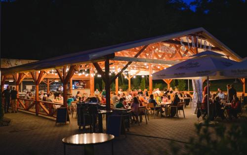 un grupo de personas sentadas en mesas en un restaurante por la noche en Septimia Hotels & Spa Resort, en Odorheiu Secuiesc