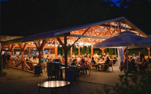a group of people sitting at tables at a restaurant at night at Septimia Hotels & Spa Resort in Odorheiu Secuiesc