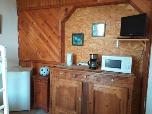 uma cozinha com um micro-ondas e uma televisão num balcão em le tilleul em Bellac