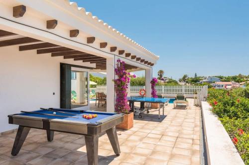 a patio with a ping pong table on a patio at Villa Marisol in Sant Lluis