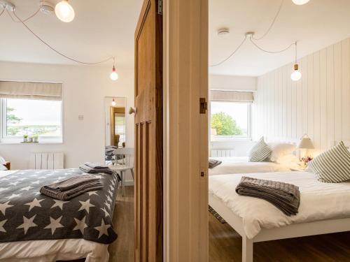 a bedroom with two beds and a mirror at Westward 8 in Polzeath