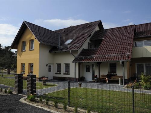 Pension + Apartments Tor zum Spreewald في لوبين: منزل امامه سياج