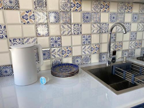 a kitchen with blue and white tiles on the wall at Express Inn in Poti