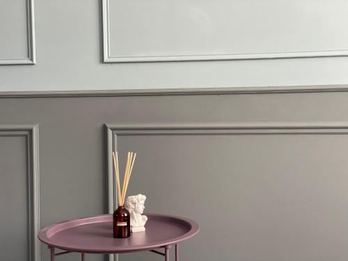 a purple table with a bottle on it next to a wall at Express Inn in Poti