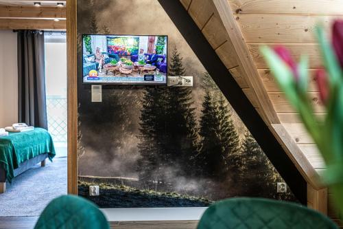 a living room with a tv on a wall at Willa Trawers in Zakopane