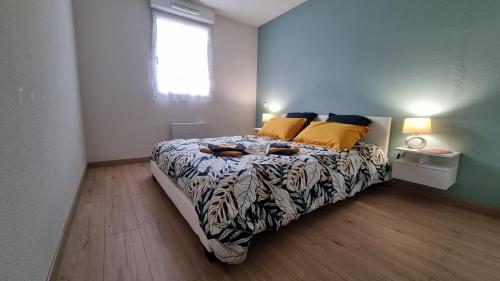 ein Schlafzimmer mit einem großen Bett mit gelben Kissen in der Unterkunft Beau T2 bien équipé au calme! ! in Saint-Pierre-du-Mont