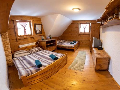 a bedroom with two beds and a television in it at Drevenica Pod Vŕškom in Terchová