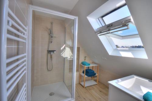 uma casa de banho com um chuveiro e um lavatório. em Rêves Bleus - Côte de Granit Rose em Ploubezre