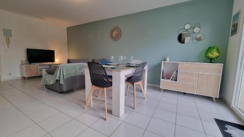 ein Wohnzimmer mit einem Tisch und 2 Stühlen in der Unterkunft Beau T2 bien équipé au calme! ! in Saint-Pierre-du-Mont